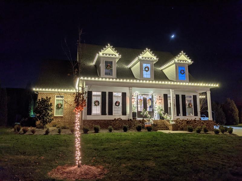 Farmhouse with dormers and a wrapped porch post