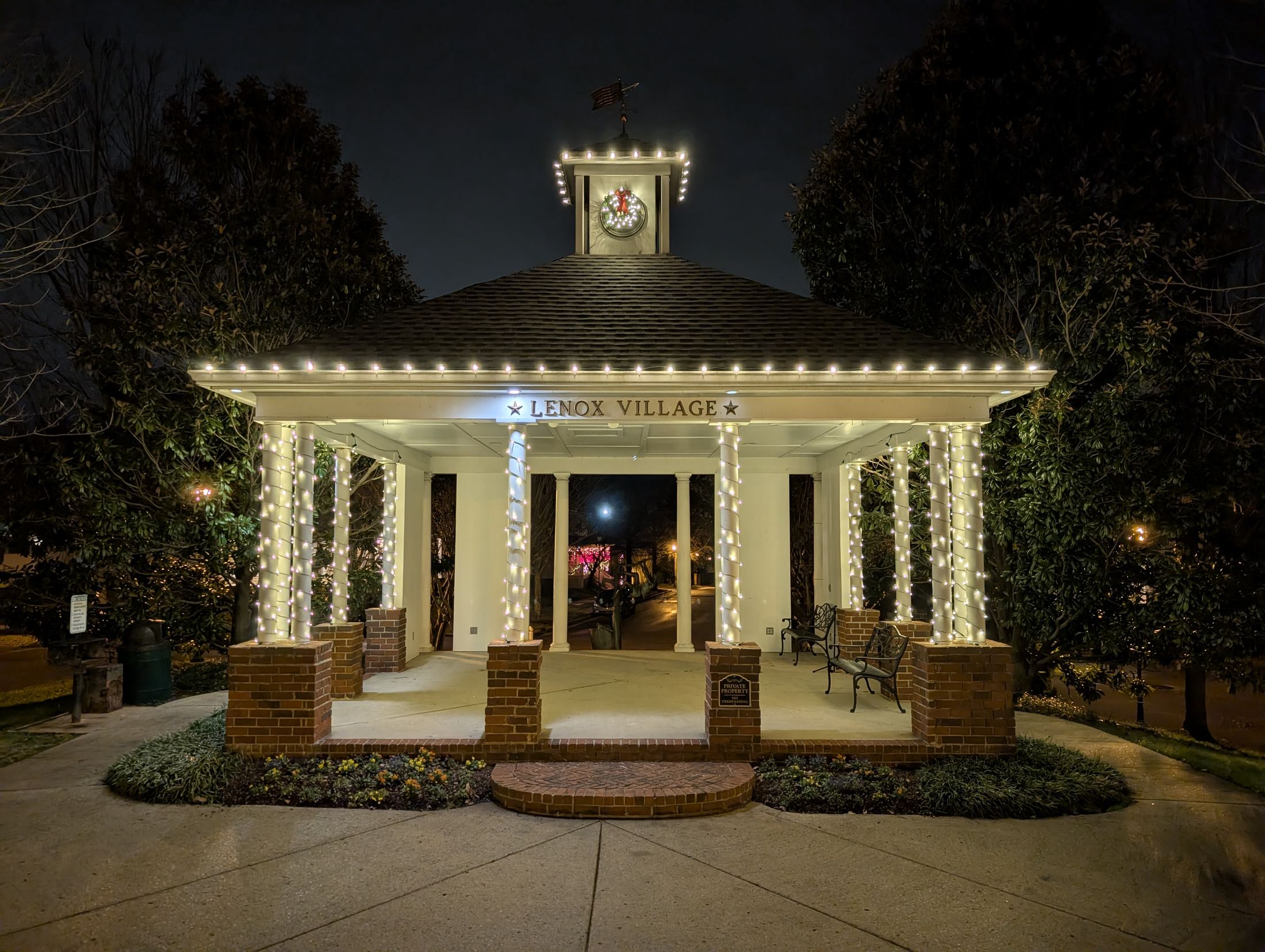 Neighborhood gazebo with wrapped columns and a lit wreath