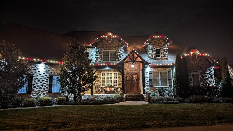 Stone home with white and red lights and uplit stonework