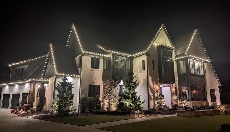 Modern home with white lights tracing sharp gables